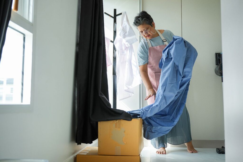 Senior woman unpacking clothing from moving boxes illustrating spring senior living transition tips at Park Place